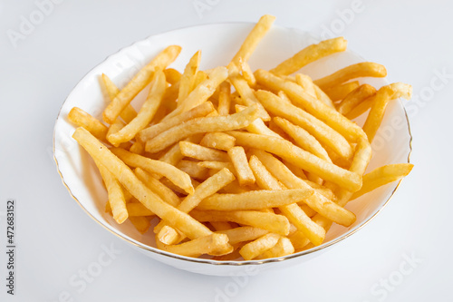 Crispy fries in a plate on white background. Hot american fast food.