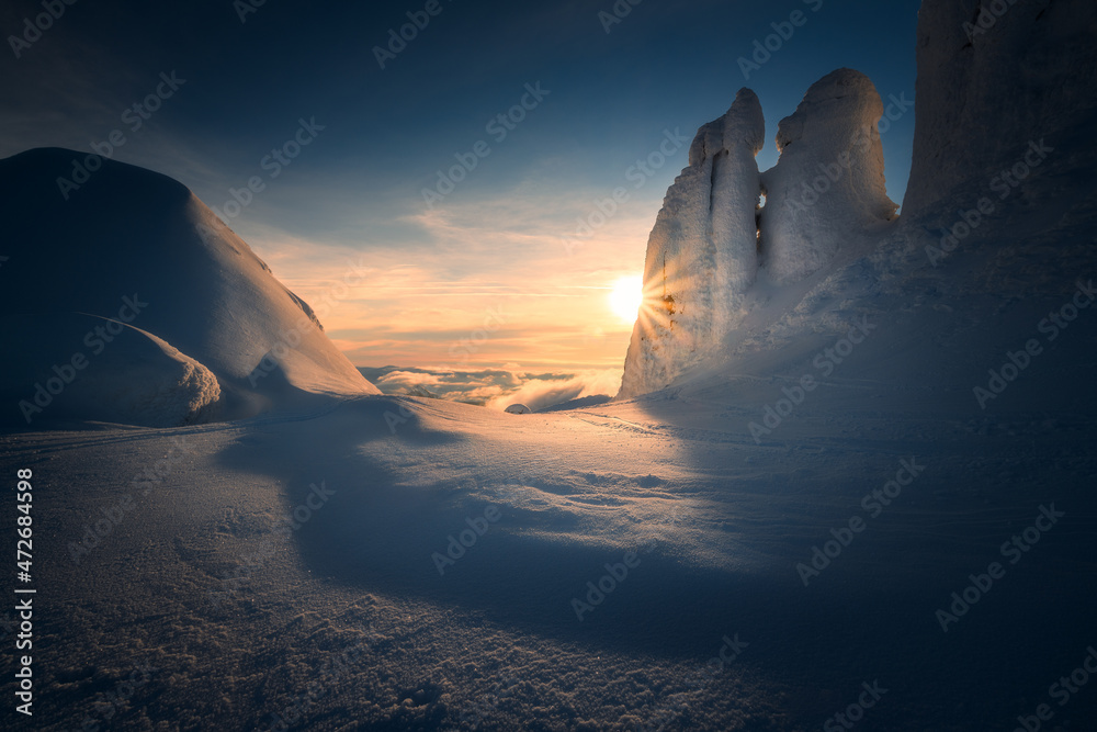 Fototapeta premium Amazing sunset scene in the mountains with some soft warm light hitting the peaks. The peaks resemble a kissing couple. Sunrise scene. Beautiful winter panorama