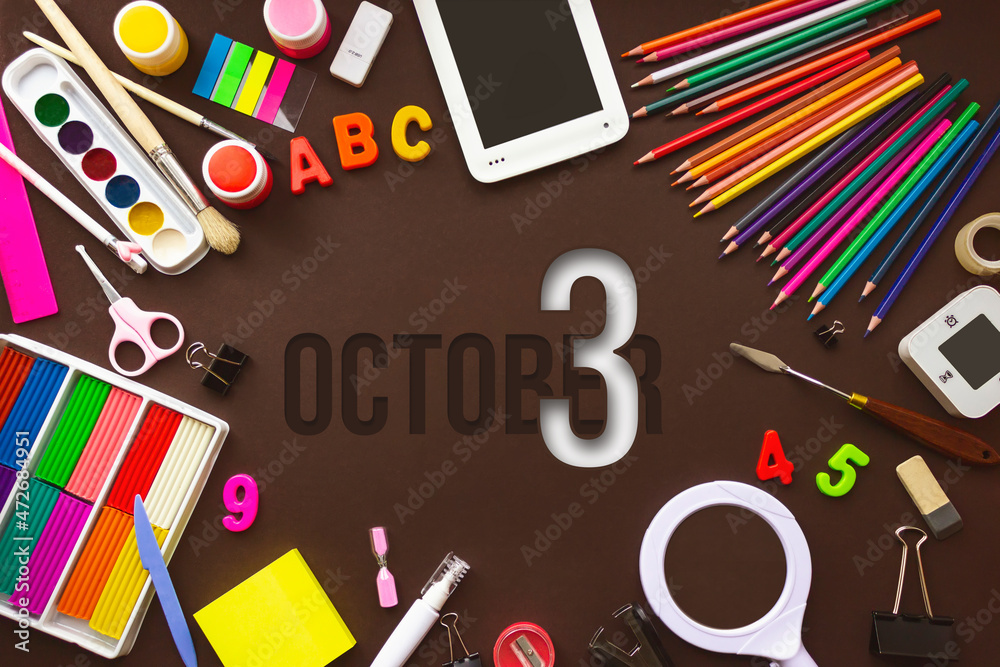 October 3rd. Day 3 of month, Calendar date. School notebook and various stationery with calendar day. School and office supplies frame. Autumn month, day of the year concept.