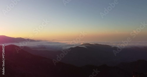 Aerial shot of the peak of the mountain range in Madari Cyprus during sunset. Over the clouds, looking the horizon photo