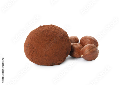 Delicious chocolate truffle with cocoa powder and hazelnuts on white background