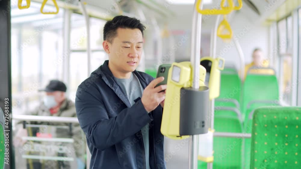 Asian man paying public city transport with mobile phone app. male ...