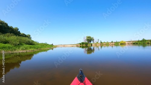  Red  Kayak on calm blue river with algae and grass. Boating team