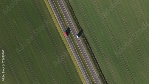 Green fields and four lanes highway from above. Cars and truck. Second part  truck following  shot.