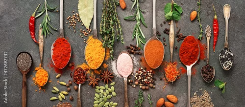 Obraz  z motywem Various spices and herbs in a spoon. Dark grunge background. Top view, flat lay. Banner