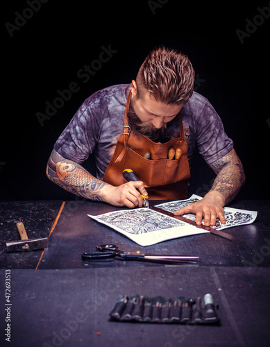 Leather Artisan forms new leather product at the work area photo
