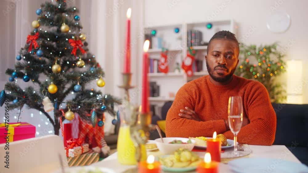 Sad young man looking at camera, sitting at the festive table alone, quarantine Sad young man looking at camera, sitting at the festive table alone, quarantine