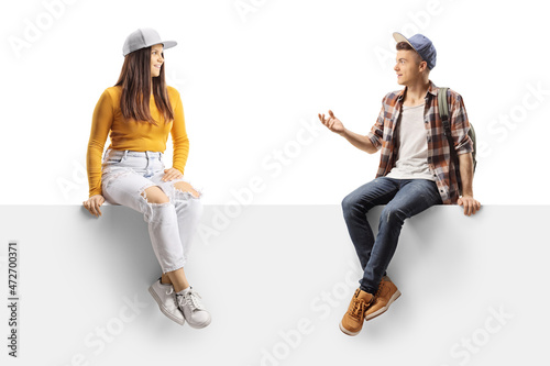 Young trendy male and female sitting on a panel and talking