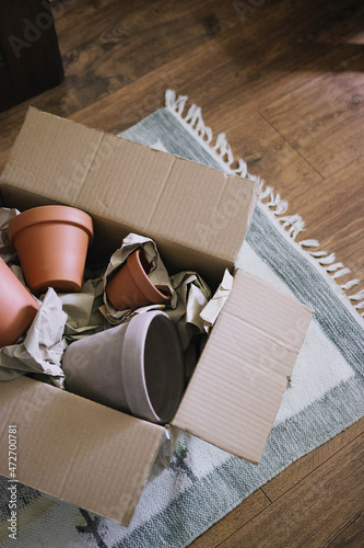 Time to make gifts. Online shopping, contactless payment, delivery to the address. Terracotta clay ceramic pots in a cardboard box. Pots for houseplants.