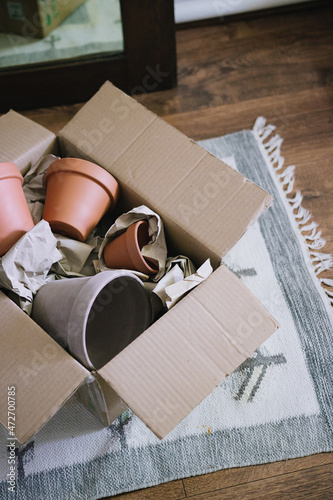 Time to make gifts. Online shopping, contactless payment, delivery to the address. Terracotta clay ceramic pots in a cardboard box. Pots for houseplants.