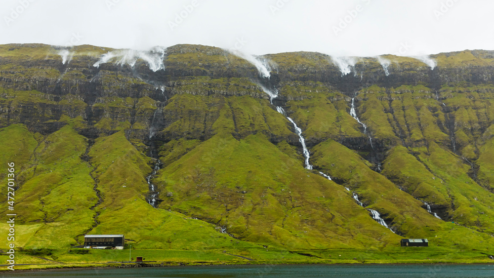Obraz premium Europe, Faroe Islands. View of the stormy hillside and waterfalls during an Atlantic gale on the island of Streymoy.