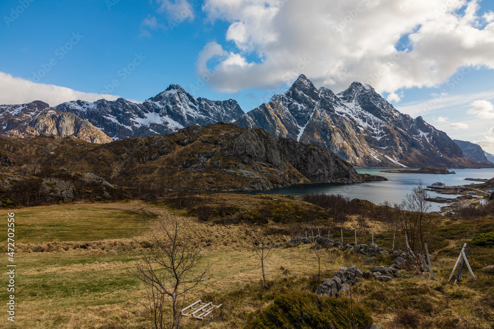 Europe, Norway. Snow covered mountains descend into the bay on Vestvagoy, a part of the Lofoten Islands in Nordland.