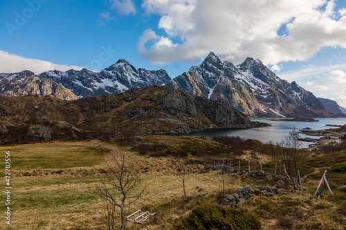 Europe, Norway. Snow covered mountains descend into the bay on Vestvagoy, a part of the Lofoten Islands in Nordland.