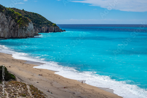 Azure vibrant waves on coast of Lefkada island. Mylos sandy idyllic beach in Greece. Summer nature travel to Ionian Sea