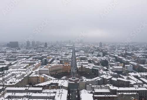 Obraz na płótnie Aerial winter cityscape of Łódż, Poland. View over the Plac Wolności and the famous tourist attraction - Piotrkowska Street with rooftops covered in snow. w salonie