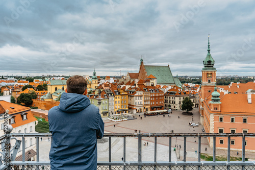 Photography Man traveler enjoying rooftop view of Royal Castle,Castle Square and Old Town,Warsaw,Poland