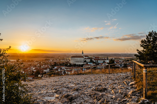 Fototapeta Naklejka Na Ścianę i Meble -  View of Mikulov with beautiful Baroque castle on the rock at sunset,south Moravia,Czech Republic.Dominant of town skyline.Czech Chateau in Palava wine region.Picturesque town among vineyards.