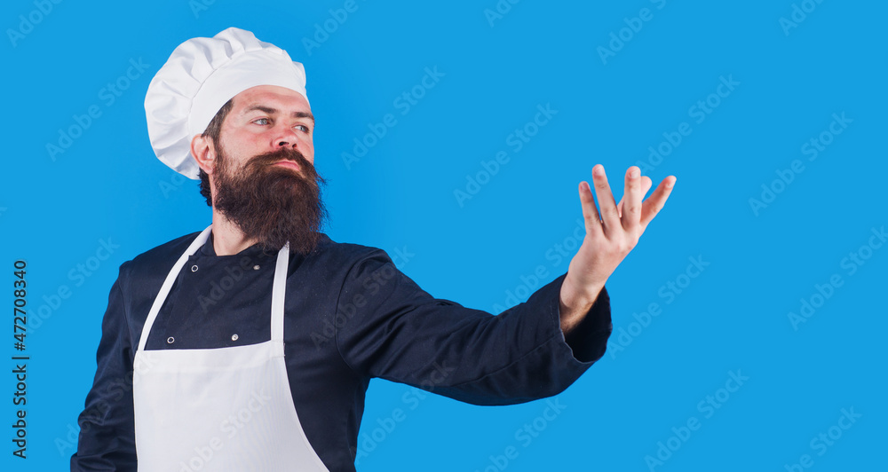 Bearded Male chef in uniform, apron and hat holds someting on hand. Copy space for advertising. Bearded Male chef in uniform, apron and hat holds someting on hand. Copy space for advertising.