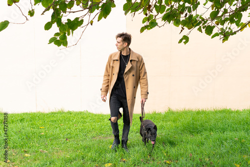 Man walking his dog in the park during the holidays. Black golden retriever. © DALU11