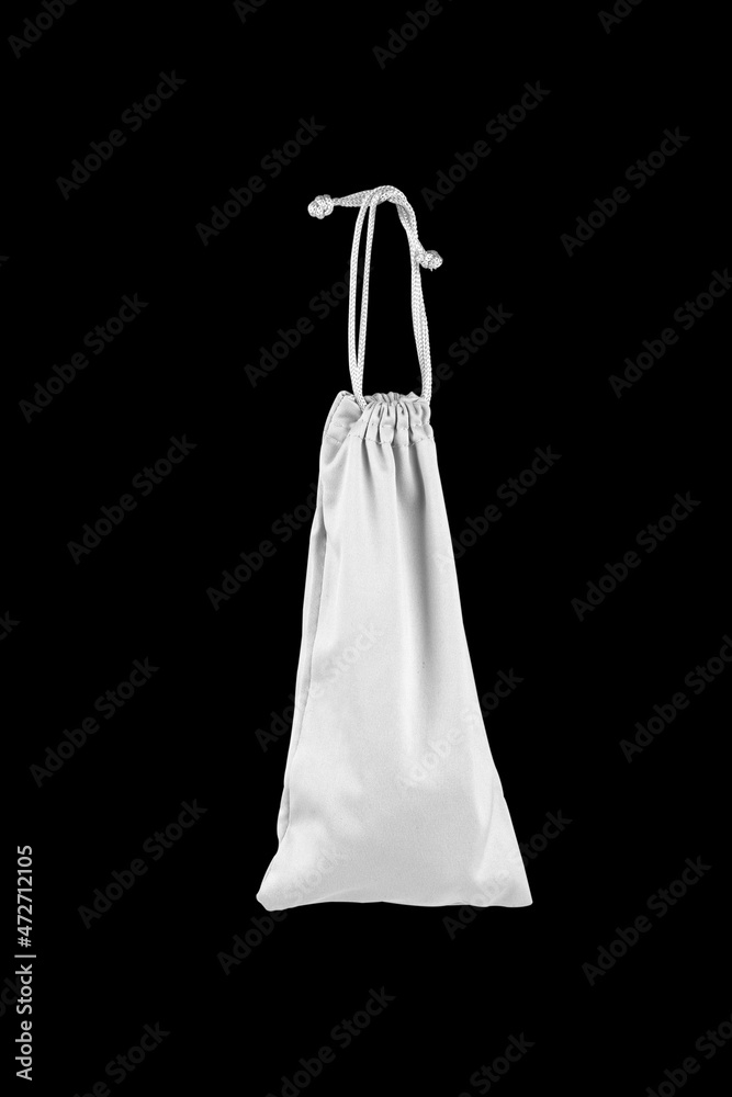 White bag on a drawstring on a black background. Small tote bag in fabric and cotton