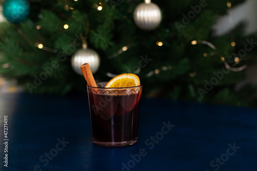 Christmas mulled wine with cinnamon stick, orange, anise and cloves on a blue background. Winter holidays.