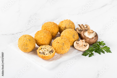 Champignons Croquettes, deep fried balls with chicken, cheese and parsley on paper on a white background