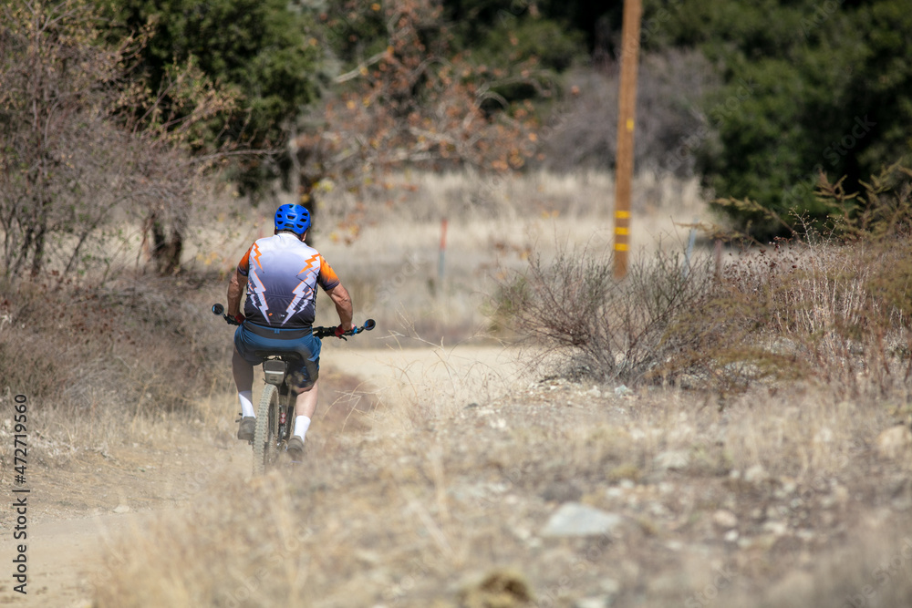 A Mature Man Mountain Biking in the California Hills on a Mountain Trail