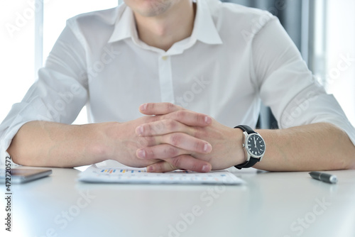 Accountant man sitting in office with business report on table.