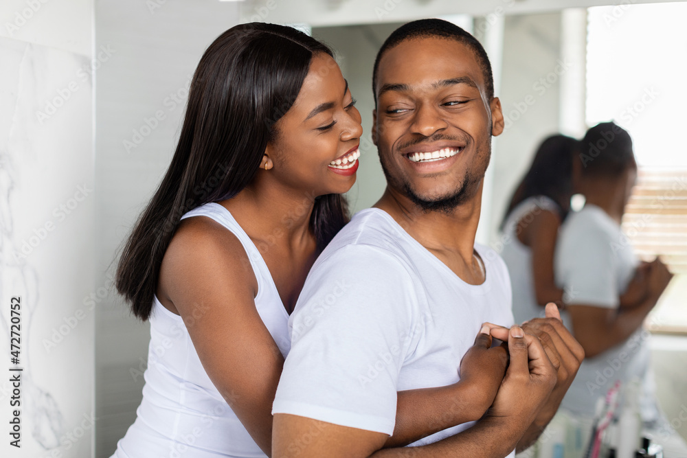 Φωτογραφία Portrait of happy young african american couple embracing near mirror in bathroo