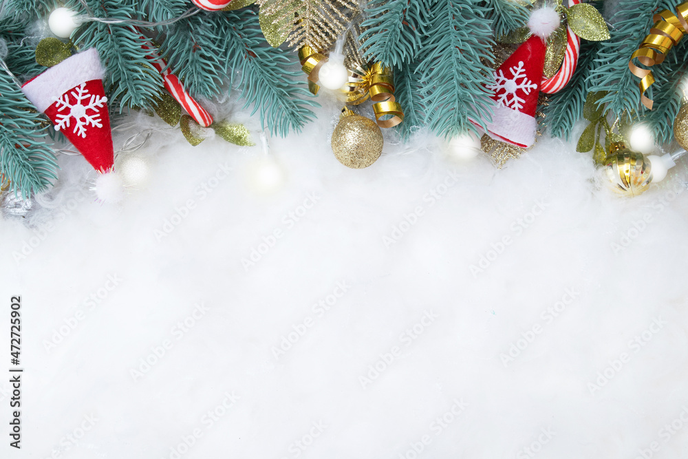 Frame made of fir branch and Christmas decorations flat lay on snowy background with copy space Frame made of fir branch and Christmas decorations flat lay on snowy background with copy space