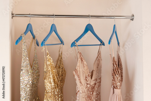 Pink women's dresses hang on wooden hangers