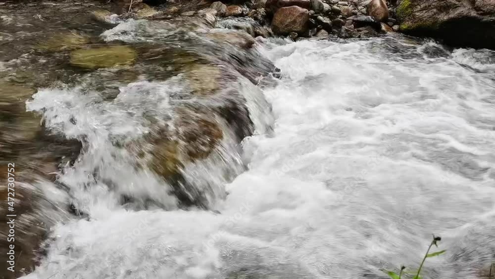 Turbulent mountain river, close up. Babbling creek flowing among stone boulders. Foamy cascade mountain stream. Turbulent mountain river, close up. Babbling creek flowing among stone boulders. Foamy cascade mountain stream.