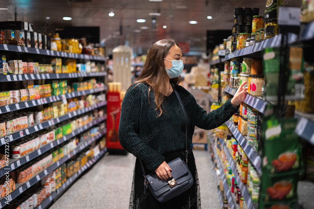 Fototapeta premium Female clients selecting groceries from shelves