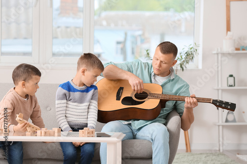 Father playing guitar and l...