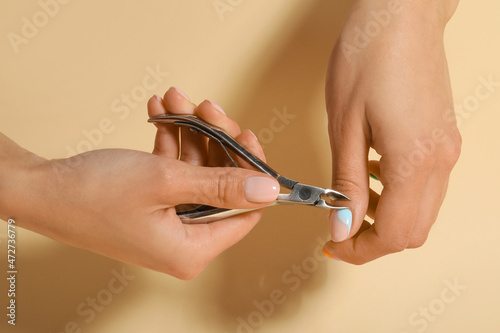 Woman doing manicure on beige background