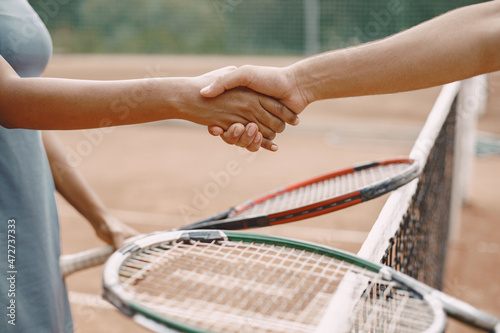 Professional tennis players shaking hands at the net © prostooleh