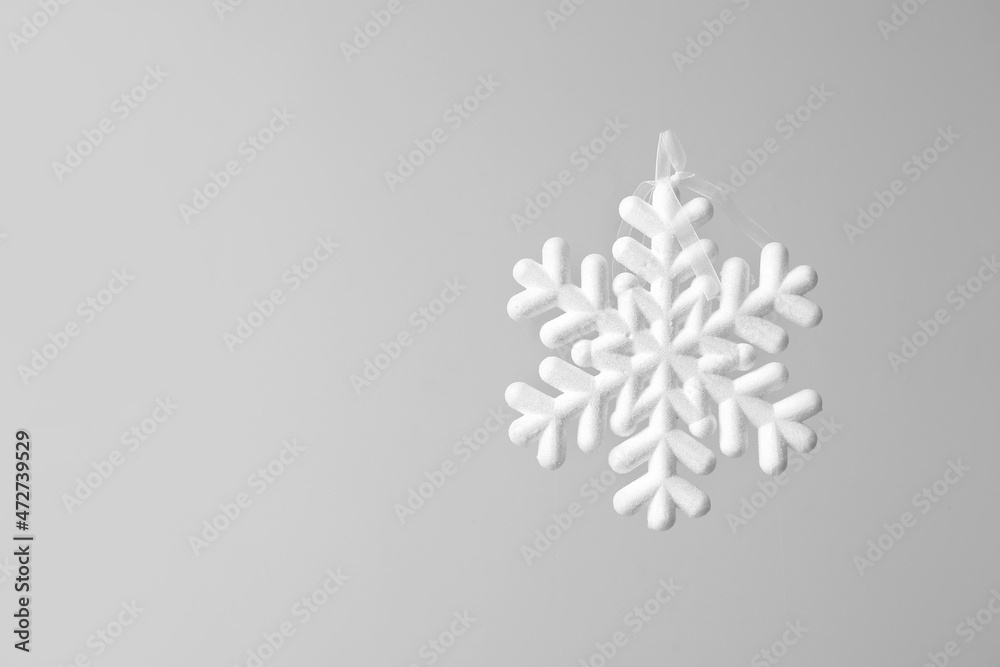 White snowflake hanging on light background White snowflake hanging on light background