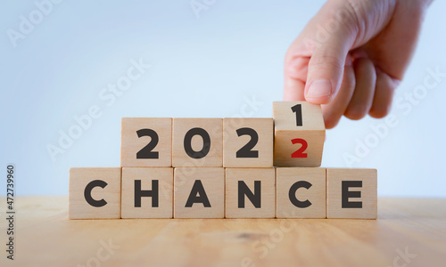 Chance concept for business or life in 2022. Hand flips the wooden cubes  2021 to 2022 with text "CHANCE" on beautiful white background and copy space. Starting new chances, opportunities in new year.