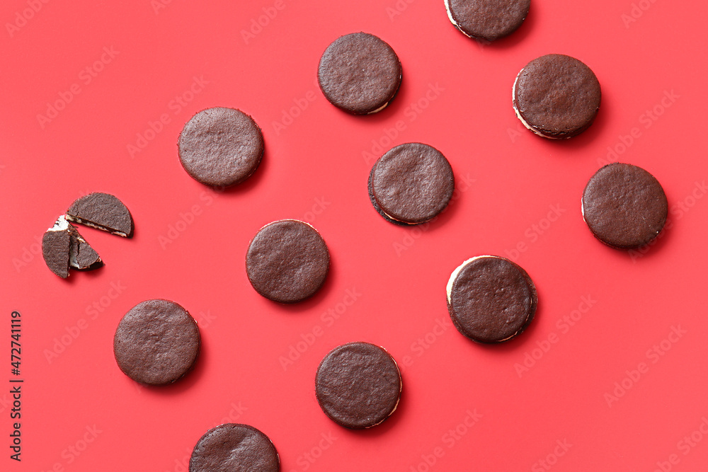 Tasty chocolate cookies with cream on red background Tasty chocolate cookies with cream on red background