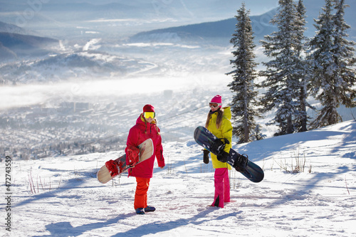 Two Woman snowboarders on the snowy mountain.