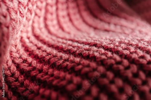 Knitted texture of a pink sweater or scarf close-up.