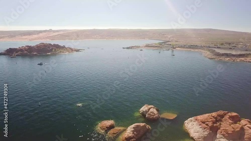 A dolly aerial shot of a great body of water, a beautiful lake in the mid-west with lots of orange rocks mid day. photo