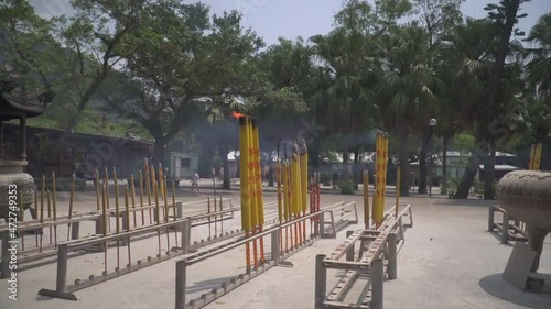 Yellow burning incense sticks in a row side by side in Po Lin Monastery in Hong Kong photo