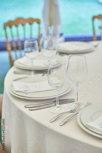 Table setting with sparkling wineglasses  plate with white napkin and cutlery on table  copy space. Place set at wedding reception. Table served for wedding banquet in restaurant