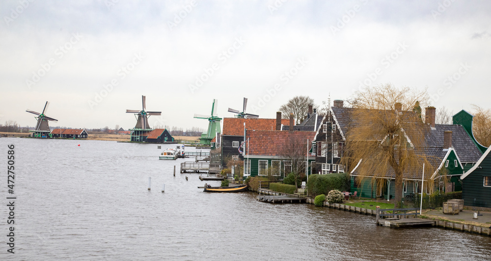 Europe, Netherlands, Zaanse Schans. Village houses and windmills along River Zaan.