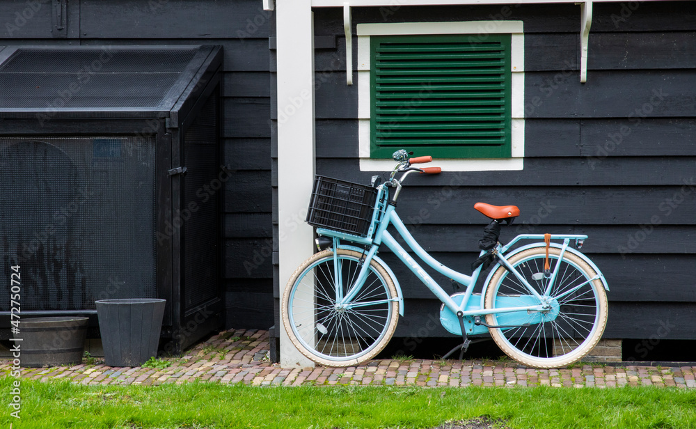 Europe, Netherlands, Zaanse Schans. Blue bicycle parked against dark wall.