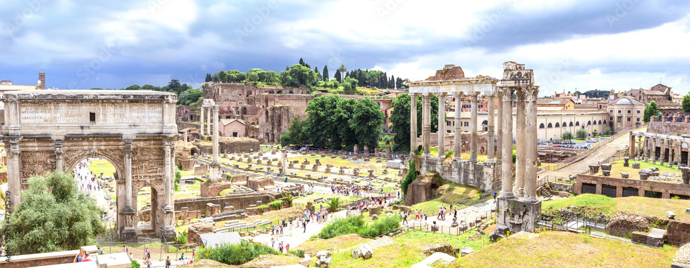 Panoramic view, aerial skyline of Roman Forum with ancient ruins of temple, columns of Saturn, Triumphal Arch of Septimius Severus, Rome, Italy.