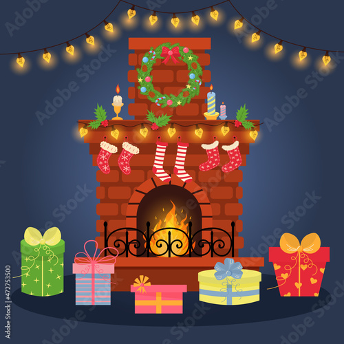 Christmas fireplace with socks, wreath, garland, holly and candles. There are gifts in front of the fireplace and a shining garland hangs above it. New year and Christmas celebration.