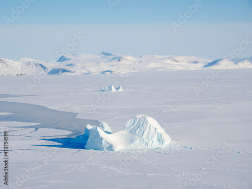 Sea ice with icebergs in the Baffin Bay, between Kullorsuaq and Upernavik in the far north of Greenland during winter. photo