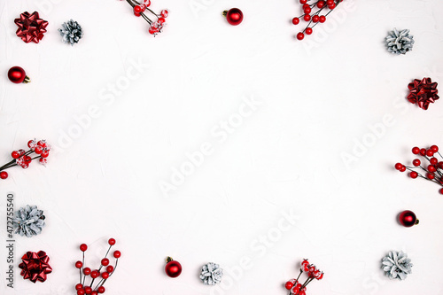 Christmas frame of cones, balls and berries on white background.